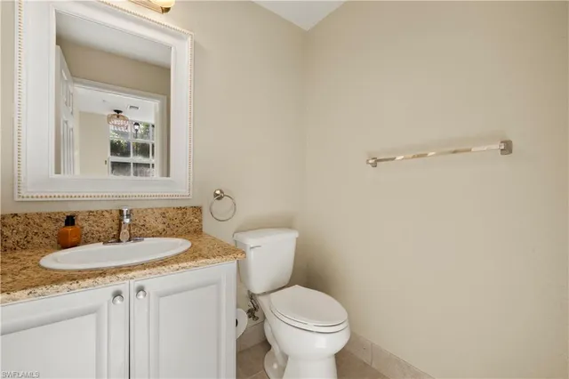 a bathroom with a granite countertop sink toilet and a mirror