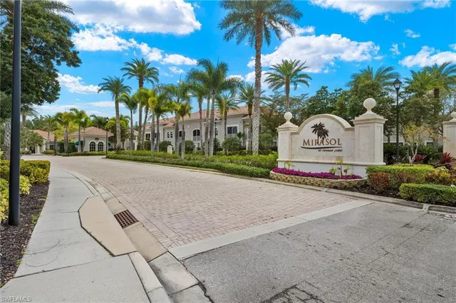 a view of white house with a yard and palm trees