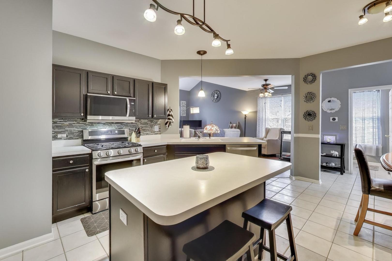 2487 Stonegate Road Algonquin, IL 60102 - Photo 3 of 39 a kitchen with a dining table chairs and refrigerator