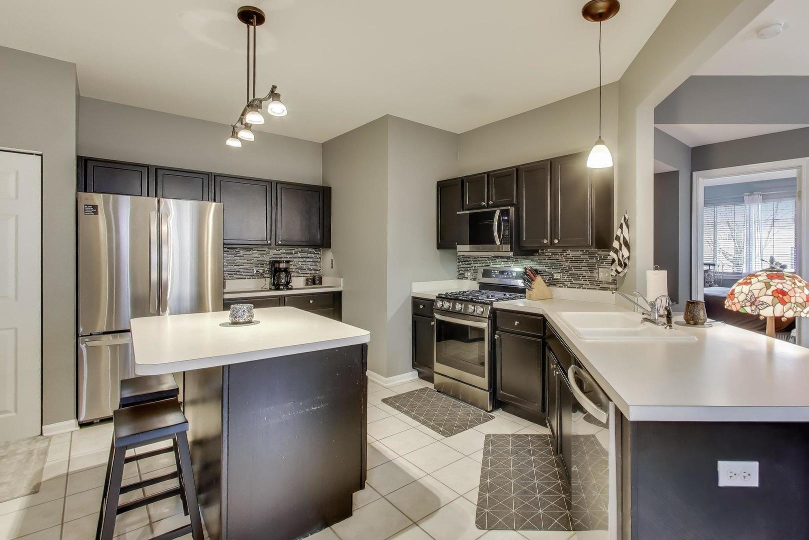 2487 Stonegate Road Algonquin, IL 60102 - Photo 4 of 39 a kitchen with kitchen island a sink stove and refrigerator