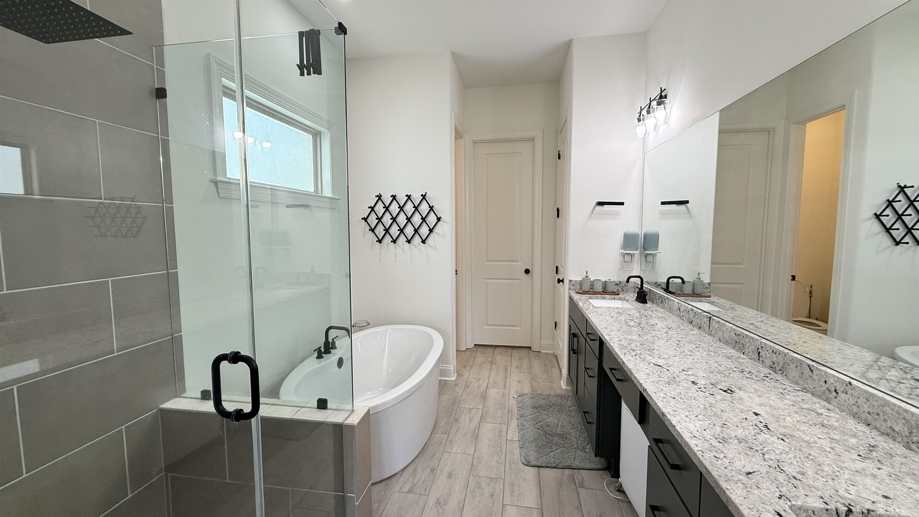 1746 Chadwick Farms Loop North Collierville, TN 38017 - Photo 13 of 35 Bathroom with a stall shower, vanity, a freestanding bath, and wood finished floors