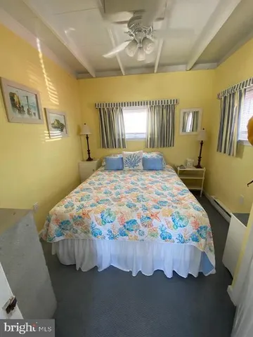 a bedroom with a bed mirror and a window