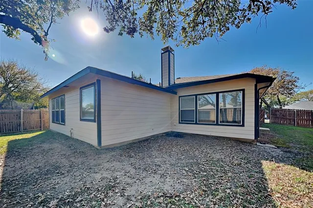 a view of a house with a yard and large tree