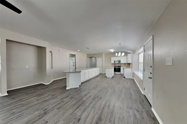 a view of a big room with wooden floor and windows
