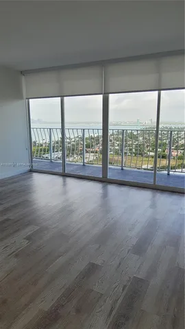 wooden floor chandelier and windows in an empty room