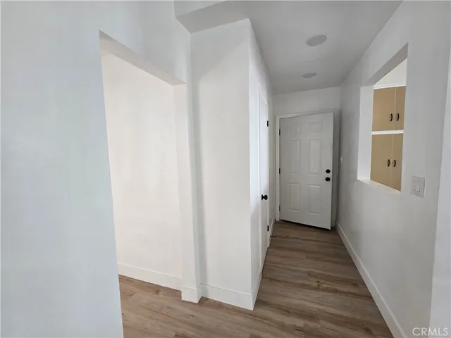 a view of a hallway with wooden floor