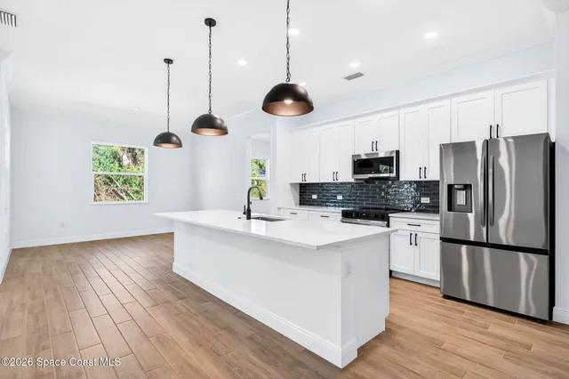 a kitchen with stainless steel appliances a stove microwave and refrigerator