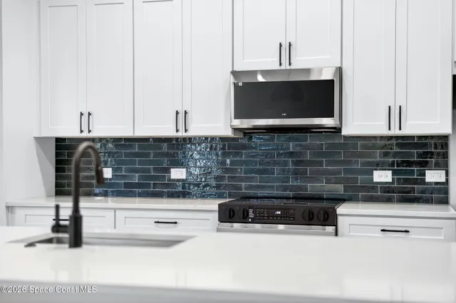 a kitchen with stainless steel appliances granite countertop a stove a sink a microwave and a refrigerator