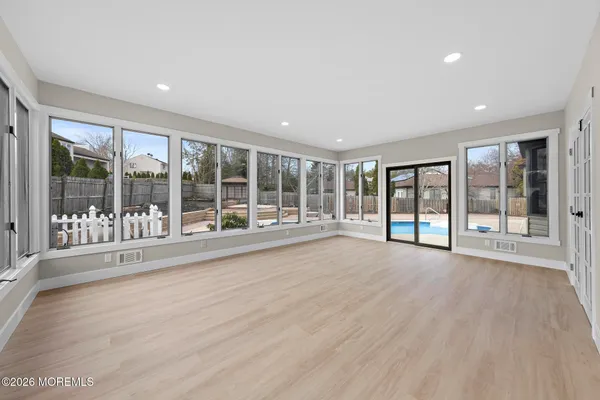 a view of an empty room with wooden floor and a floor to ceiling window