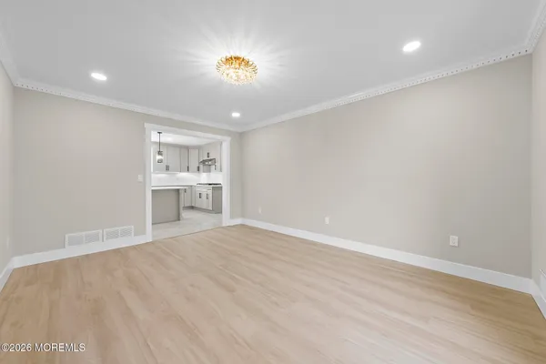 a view of empty room with kitchen and window