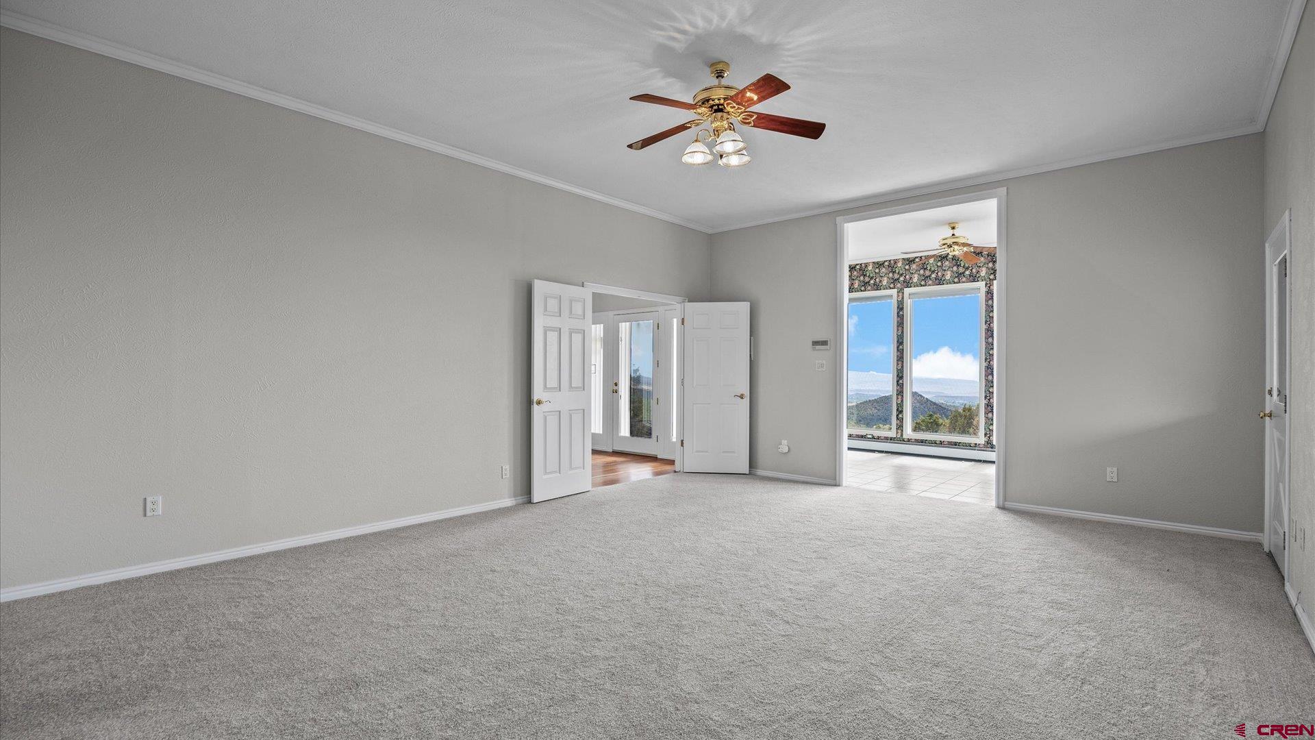20508 Green Valley Road Cedaredge, CO 81413 - Photo 22 of 42 an empty room with windows and chandelier fan