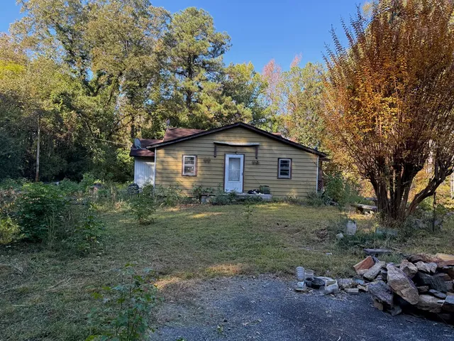 a view of a barn house in middle of the forest