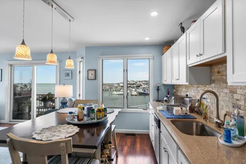 a kitchen with a dining table chairs sink and cabinets