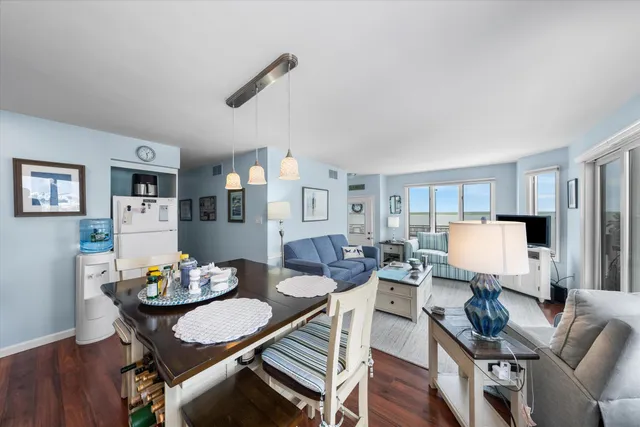 a kitchen with a stove a refrigerator and white cabinets with wooden floor