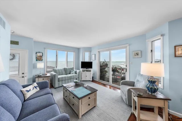 a living room with furniture large window and a wooden floor