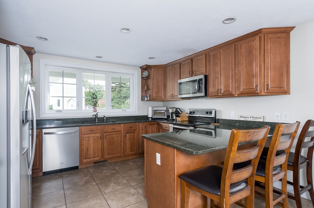 6 Carlson's Way Rutland, MA 01543 - Photo 4 of 34 a kitchen with stainless steel appliances granite countertop a sink stove refrigerator and microwave