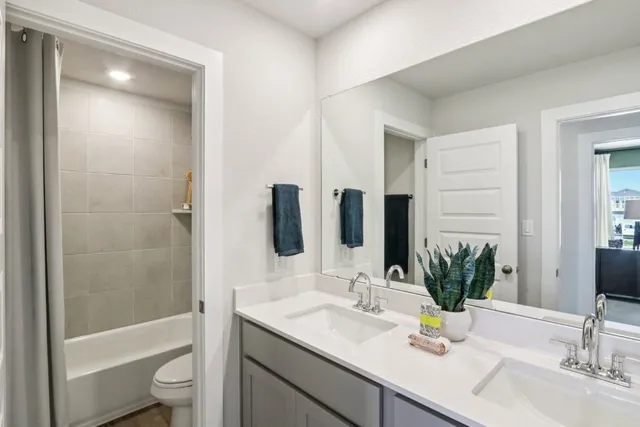 a bathroom with a granite countertop sink a toilet and shower