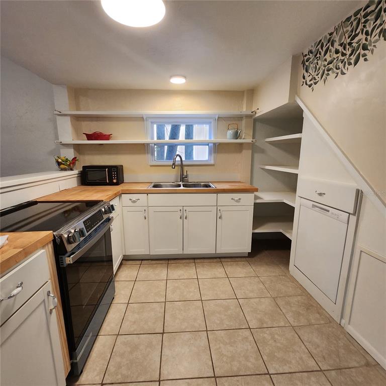 809 Northwest 4th Avenue Gainesville, FL 32601 - Photo 5 of 15 a kitchen with a stove a sink and a refrigerator