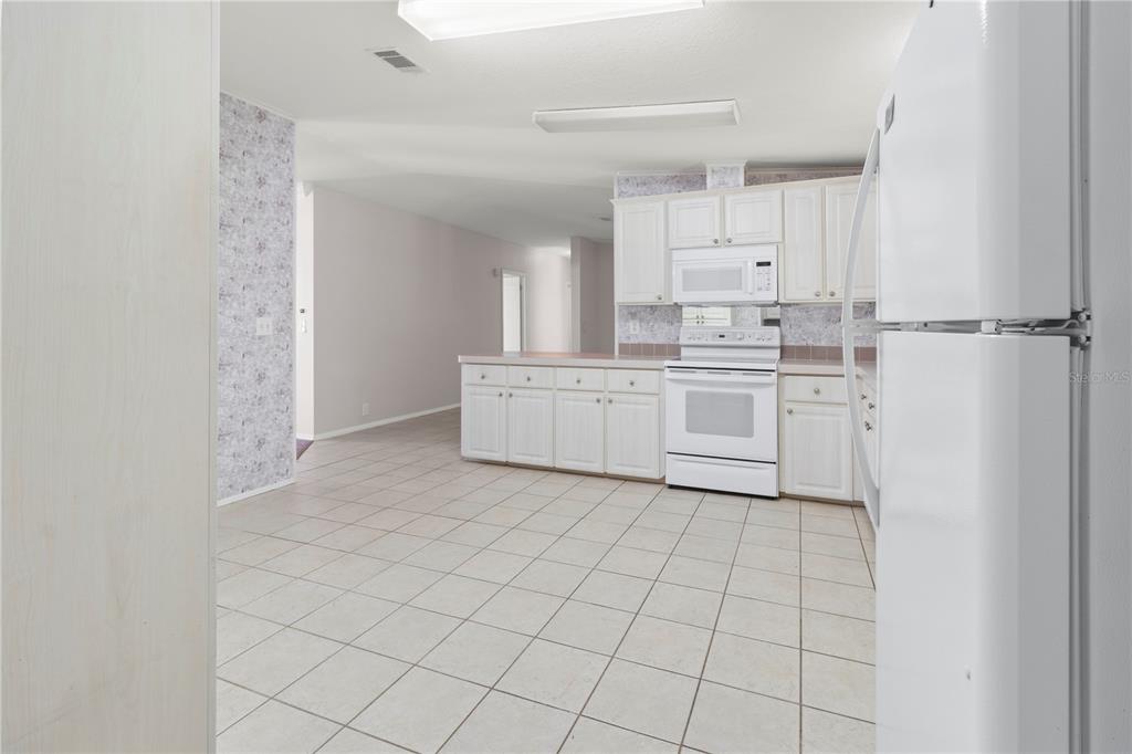 8307 Nancy Lane Ellenton, FL 34222 - Photo 11 of 57 a kitchen with white cabinets and white appliances