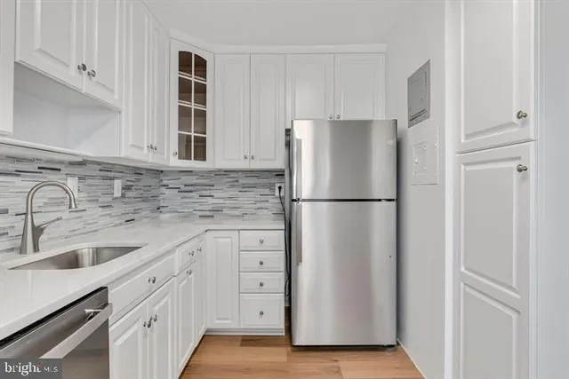 a kitchen with appliances a sink and cabinets