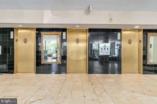a view of a hallway with wooden floor and a living room