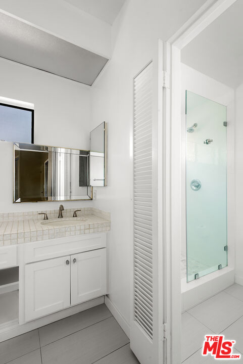 1944 Glendon Avenue, Unit 309 Los Angeles, CA 90025 - Photo 18 of 30 a bathroom with a double vanity sink and mirror