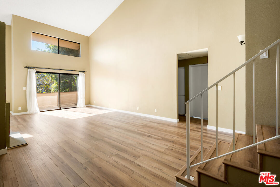 1944 Glendon Avenue, Unit 309 Los Angeles, CA 90025 - Photo 2 of 30 a view of an empty room with wooden floor and windows