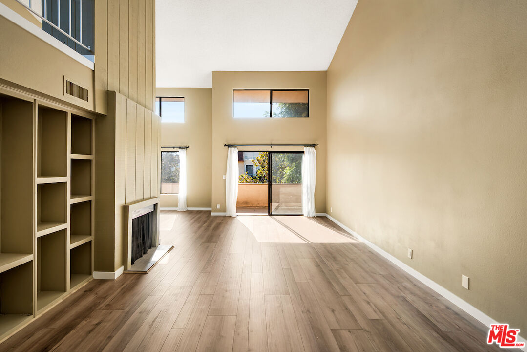 1944 Glendon Avenue, Unit 309 Los Angeles, CA 90025 - Photo 4 of 30 a view of an empty room with wooden floor and a window