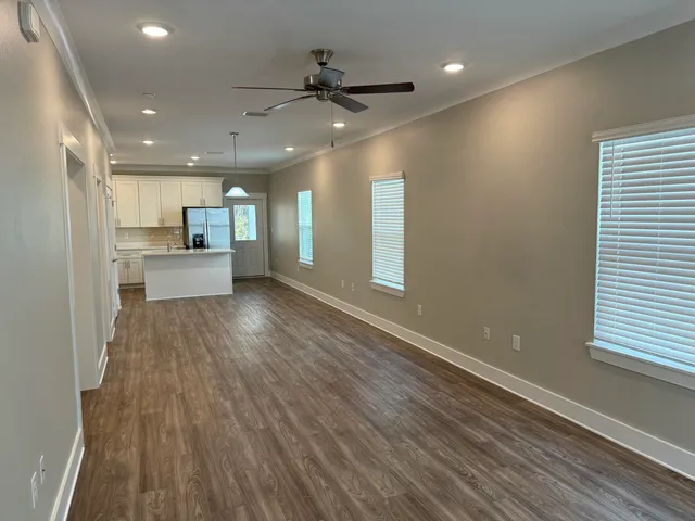a view of large kitchen with a sink and wooden floor