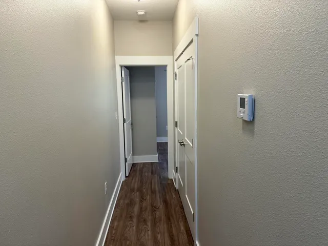 a view of a hallway with wooden floor and a hallway