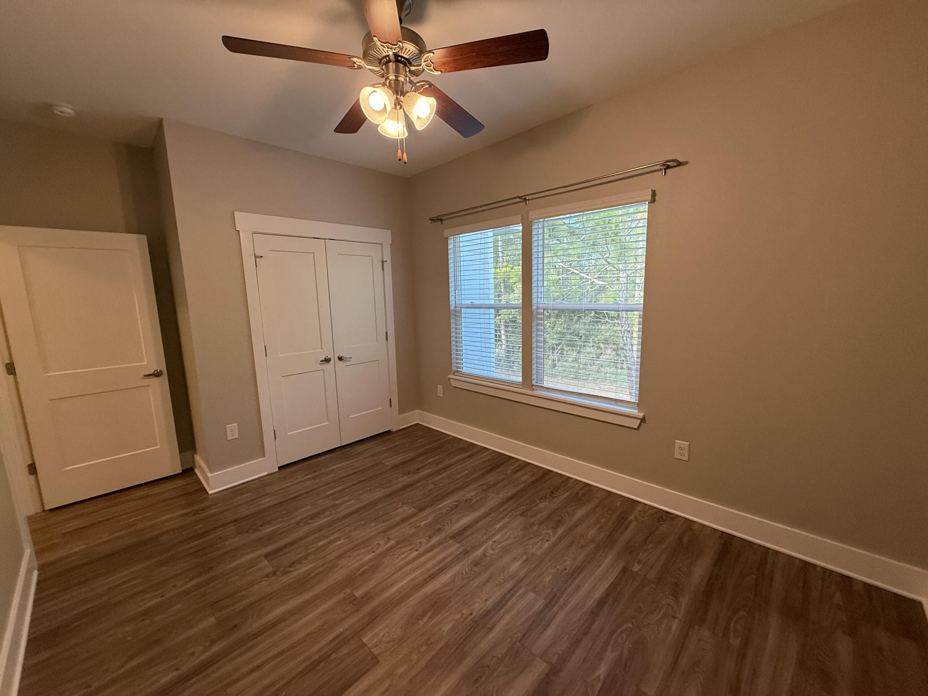 142 North Sand Palm Road Freeport, FL 32439 - Photo 25 of 26 an empty room with wooden floor fan and windows