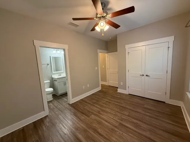 a view of a room with wooden floor and a ceiling fan