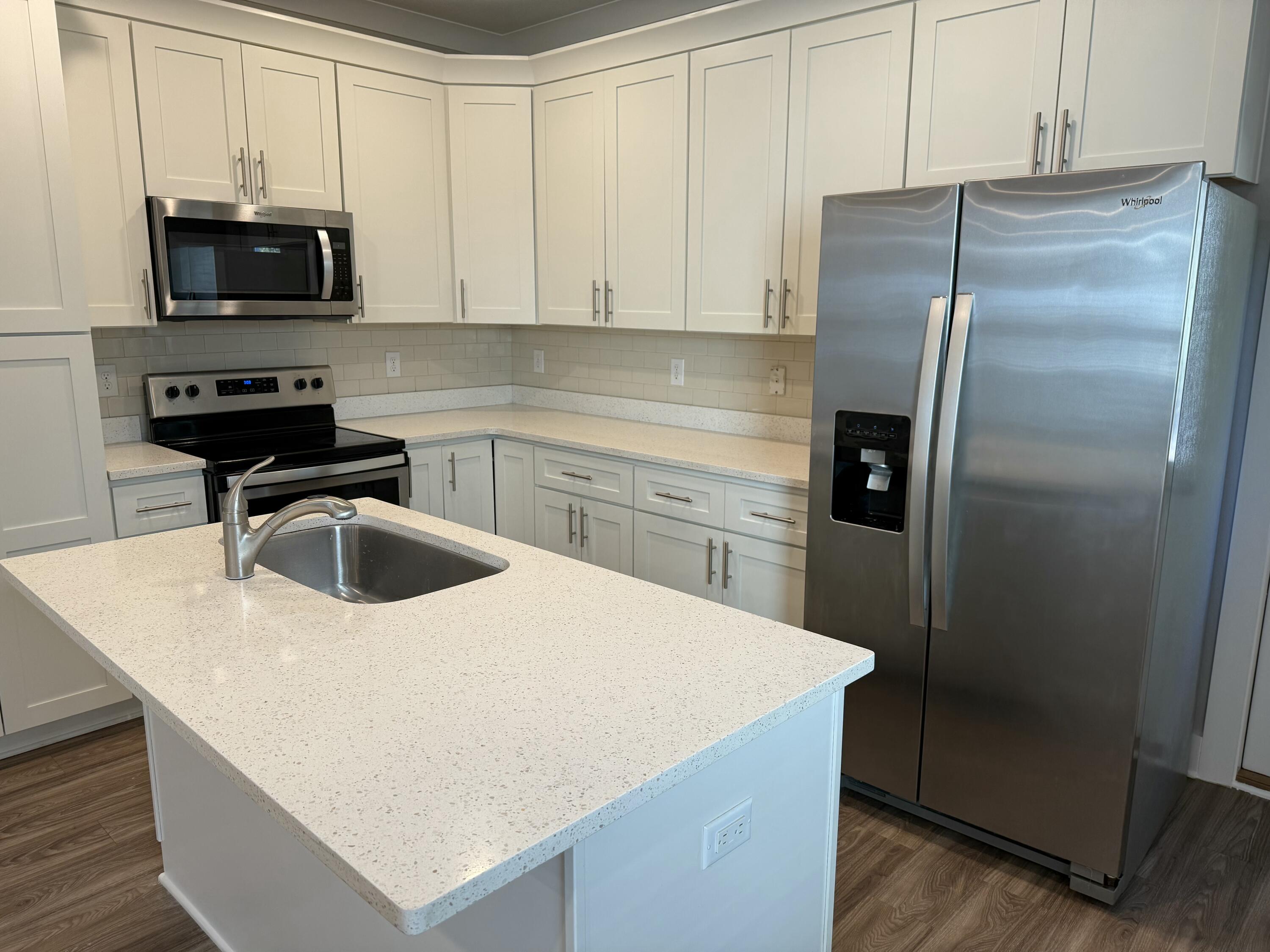 142 North Sand Palm Road Freeport, FL 32439 - Photo 10 of 26 a kitchen with kitchen island a counter appliances a sink and cabinets