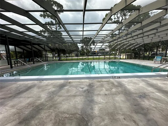 a view of a swimming pool with a bench in patio