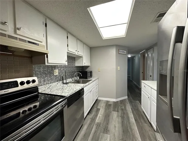 a kitchen with stainless steel appliances a sink stove and refrigerator