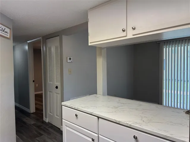a kitchen with a white cabinets and a wooden floor