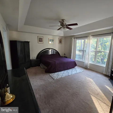 a spacious bedroom with a bed and a large window