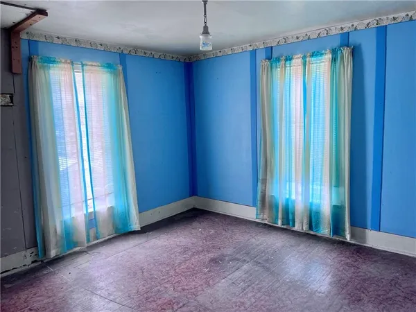 an empty room with window and closet area