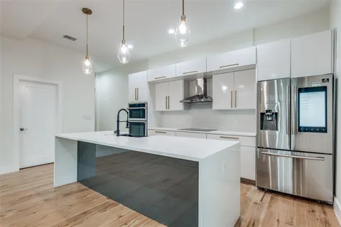 a kitchen with stainless steel appliances granite countertop a stove a sink and a microwave