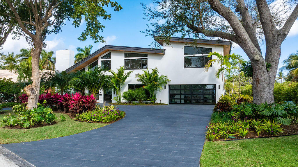 3001 Northeast 52nd Street Lighthouse Point, FL 33064 - Photo 4 of 61 a front view of a house with a garden