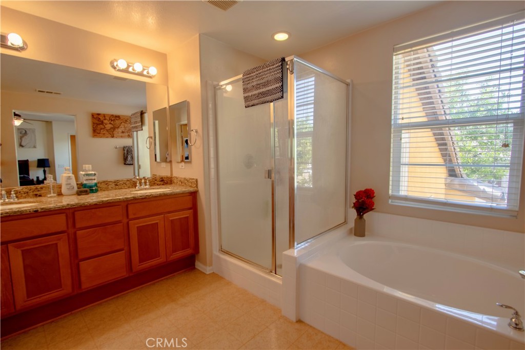 8090 Cornwall Court, Unit 38 Rancho Cucamonga, CA 91739 - Photo 21 of 47 a bathroom with a tub sink shower and a mirror
