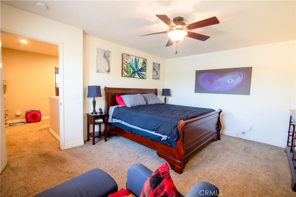 8090 Cornwall Court, Unit 38 Rancho Cucamonga, CA 91739 - Photo 25 of 47 a bedroom with a bed and a chandelier