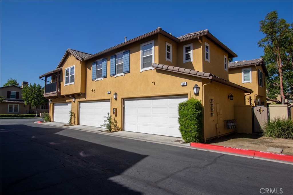 8090 Cornwall Court, Unit 38 Rancho Cucamonga, CA 91739 - Photo 38 of 47 a front view of a house with a yard and garage
