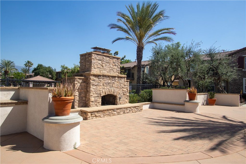 8090 Cornwall Court, Unit 38 Rancho Cucamonga, CA 91739 - Photo 44 of 47 a view of a white house with a couches chair and a fire pit with swimming pool