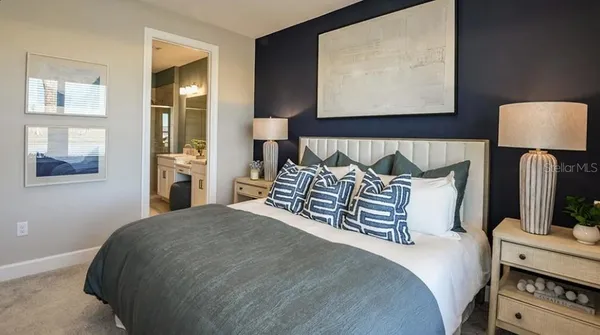 a bed sitting in a bedroom next to a lamp