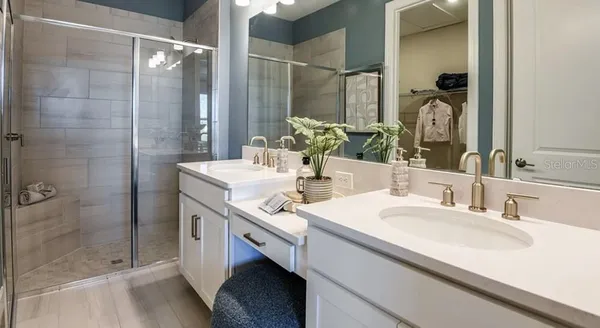 a bathroom with a double vanity sink mirror and shower