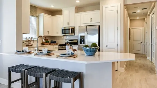 a kitchen with a sink a stove and chairs