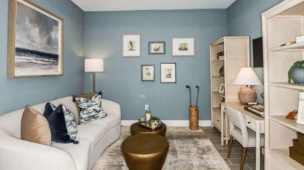 a living room with furniture and a painting on the wall