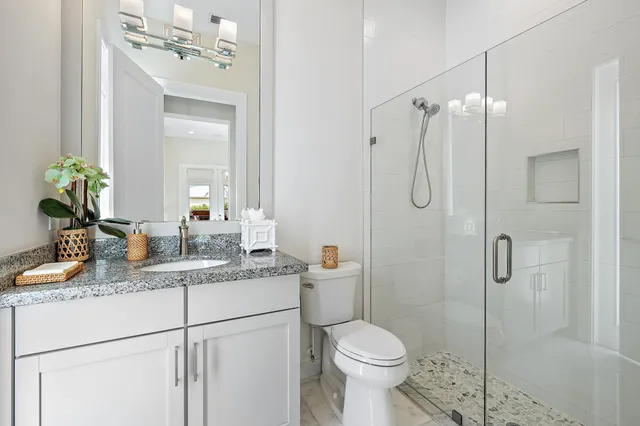 a bathroom with a granite countertop toilet a sink and shower