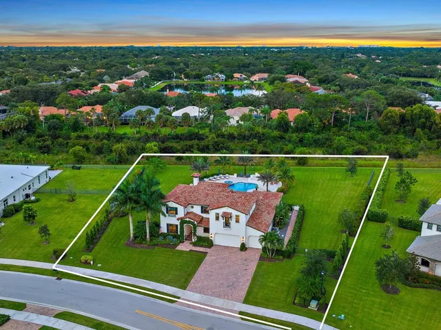 a view of a fountain in front of a house with a big yard